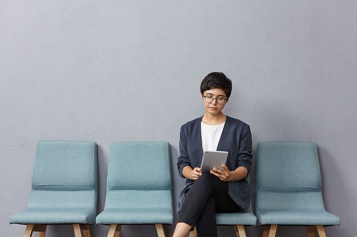 Woman reading a job application on tablet.